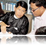 Sotheara Chhim, Executive Director of the Transcultural Psychosocial Organization Cambodia (right), consults with visitors Burma representives from the Assistance Association for Political Prisoners and Social Action for Women on mental health.